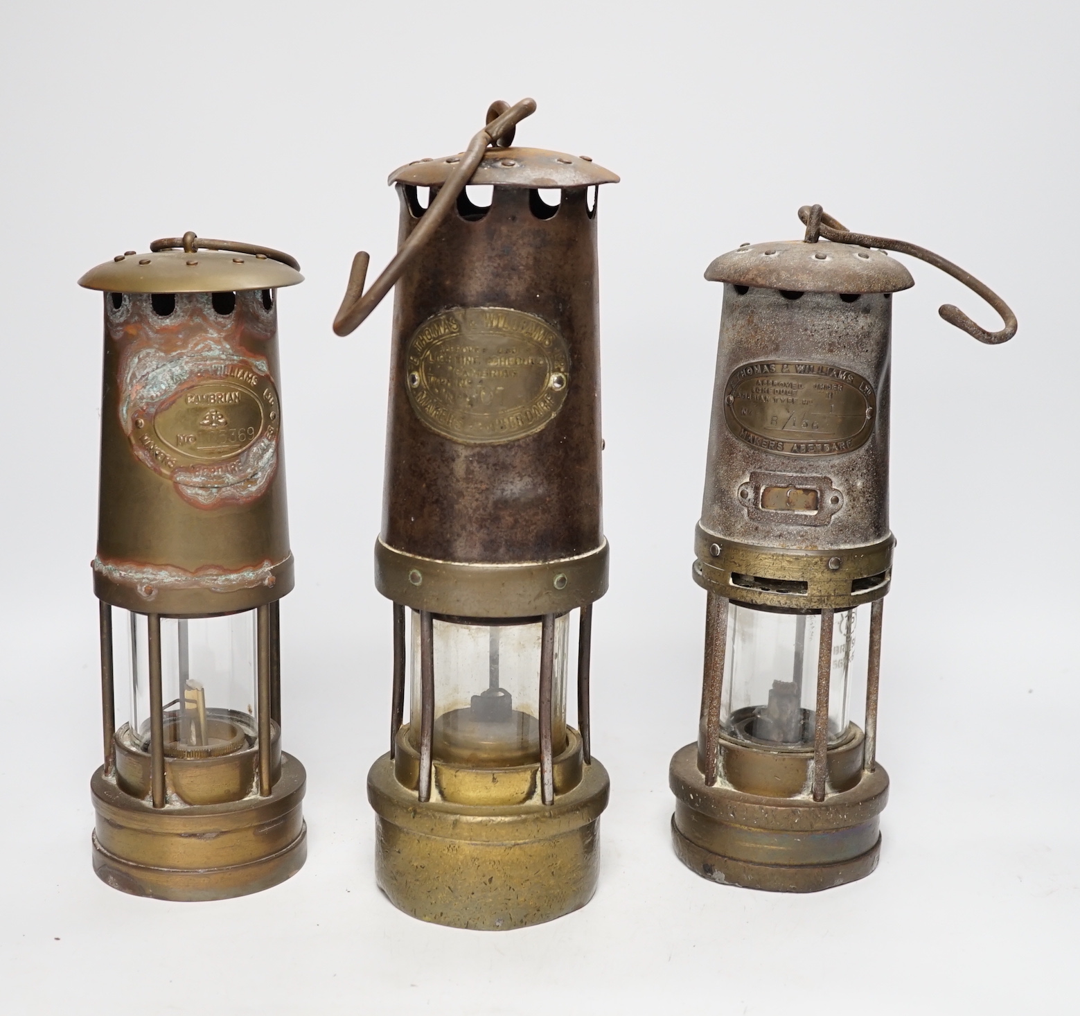 Three Thomas & Williams miner's lamps, tallest 30cm